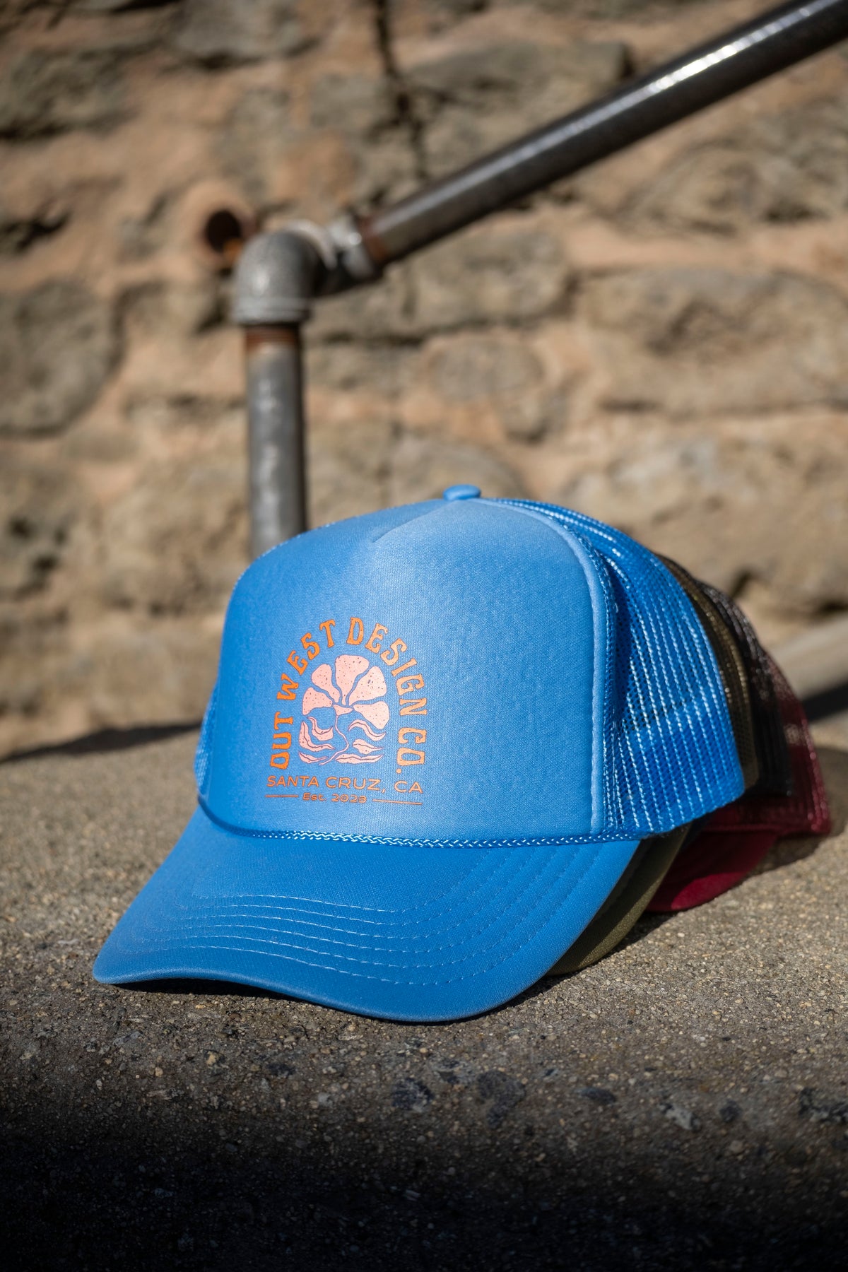 Blue cap with a logo on a stone surface